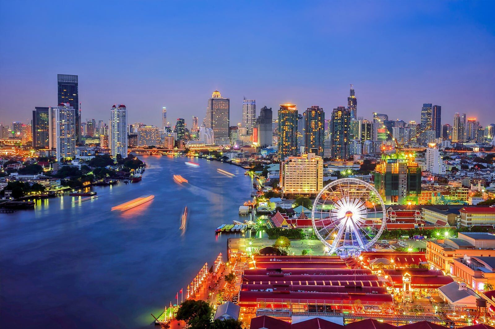 Bangkok riverfront at dusk with the Asiatique waterfront and CBD skyline along the Chao Phraya